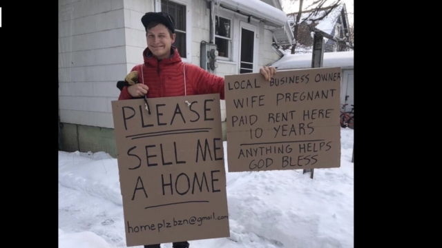 Man holds up a sign