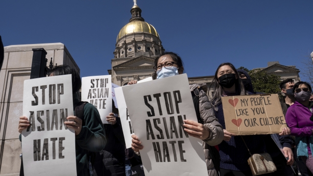 People hold signs at "Stop Asian Hate" rally