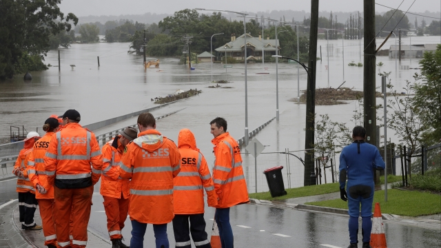 State Emergency Service personnel gather at the entrance to a submerged bridge surrounded by water