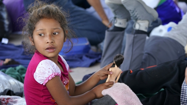 A young migrant girl from Honduras, plays with a doll.