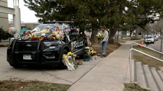 Woman puts flowers on the cop car.