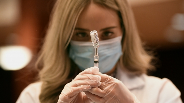 Pharmacist draws a syringe of vaccine