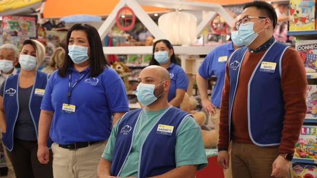 Masked retail workers from sitcom "Superstore" stand together.