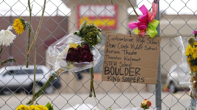 Sign listing mass shootings in Colorado hangs in front of King Soopers grocery store.