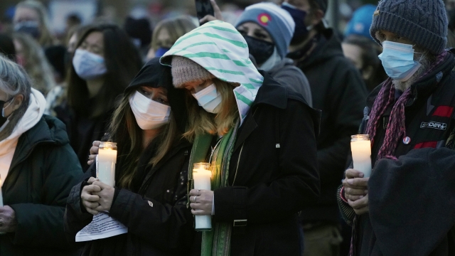 Mourners console each other at a vigil for the 10 victims of the Monday massacre at a King Soopers grocery store.