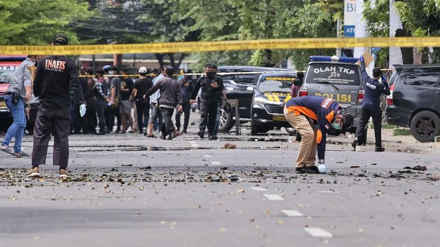 Police officers inspect the area near a church where an explosion went off in Makassar, South Sulawesi, Indonesia.