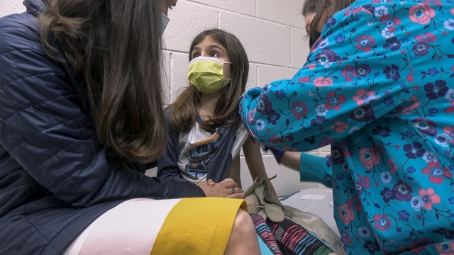 Alejandra Gerardo, 9, looks up to her mom, Dr. Susanna Naggie, as she gets the first of two Pfizer COVID-19 vaccinations.