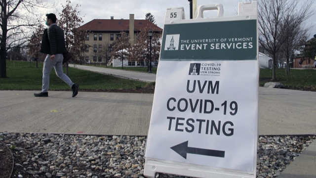 A University of Vermont student walks toward a tent leading to a COVID-testing site on campus in Burlington, Vt.