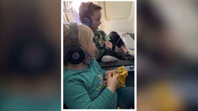 Kids sit on an airplane.