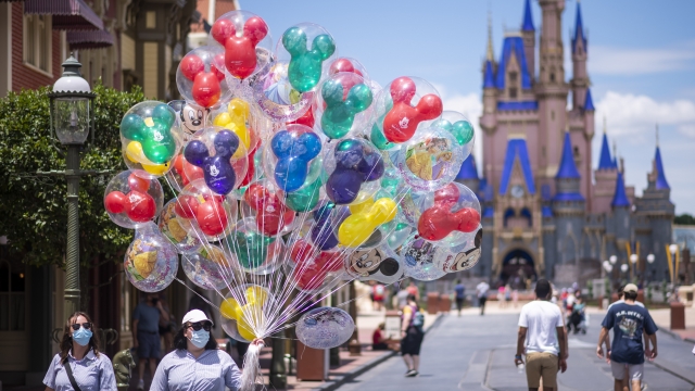 Balloon vendors wear required face masks due to the Covid-19 pandemic in front of Cinderella Castle at Walt Disney World.