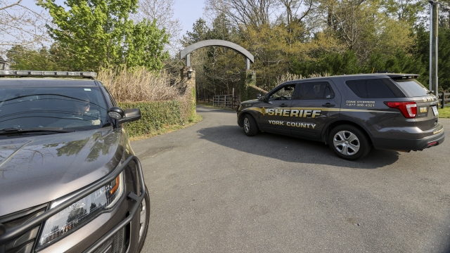 A York County sheriff vehicle drives onto the property where multiple people, including a prominent doctor, were fatally shot