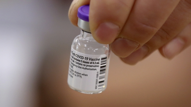 Holding a dose of the COVID-19 vaccine