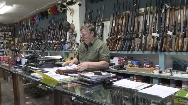 Gun shop owner sorts paperwork.