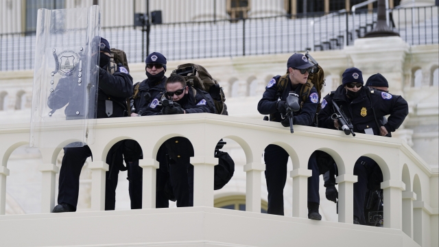 Police keep a watch on demonstrators who tried to break through a police barrier at the Capitol in Washington.