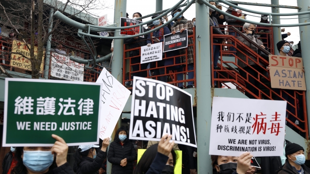 Demonstrators holding signs take part in a rally against Asian hate crimes