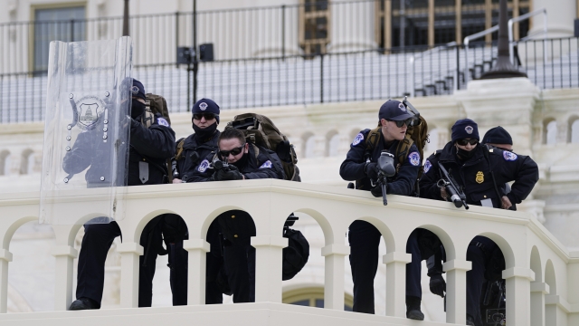 Police keep a watch on demonstrators who tried to break through a police barrier at the Capitol in Washington.