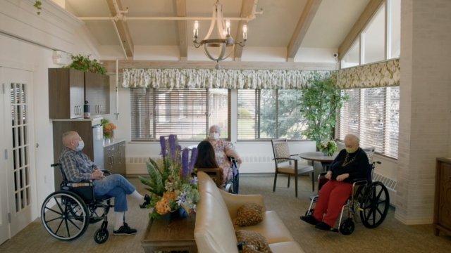 Seniors sit in a nursing home.