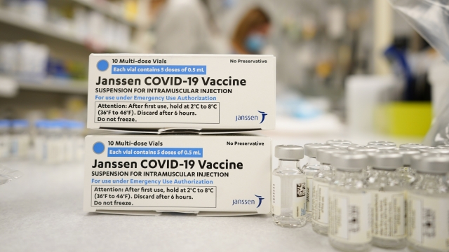 Boxes stand next to vials of Johnson & Johnson COVID-19 vaccine.