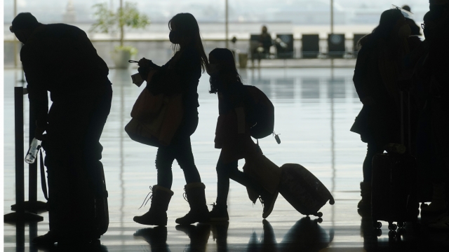 Silhouette of travelers walking through an airport.