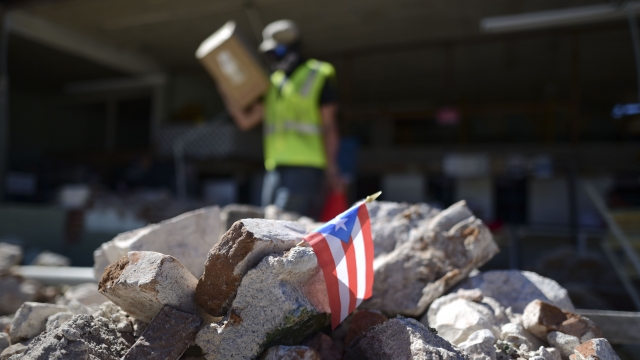 A Puerto Rican flag hangs within the rubble after an earthquake Tuesday, Jan. 7, 2020