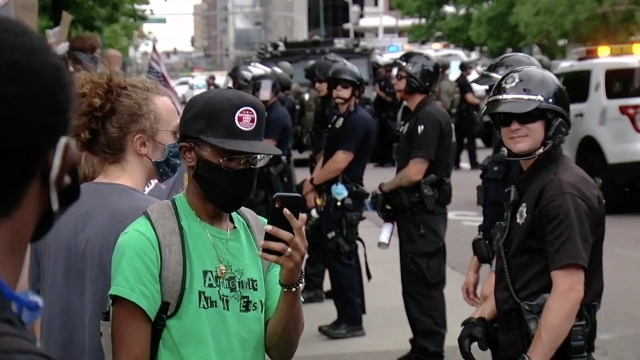 Protester stands by a policeman.