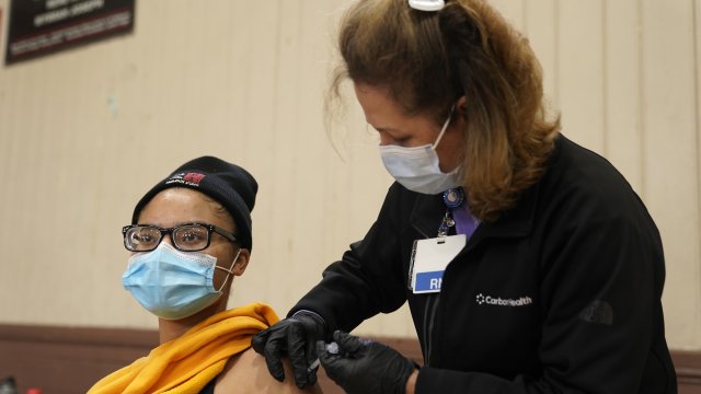 A person receives a dose of the Pfizer COVID-19 vaccine at the Banning Recreation Center in Wilmington, Calif.