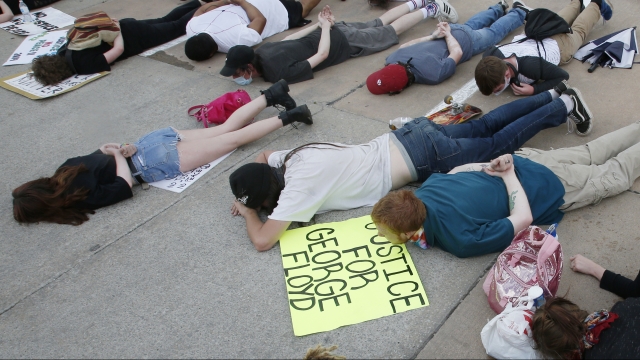 Demonstrators lie face down depicting George Floyd during his detention by police