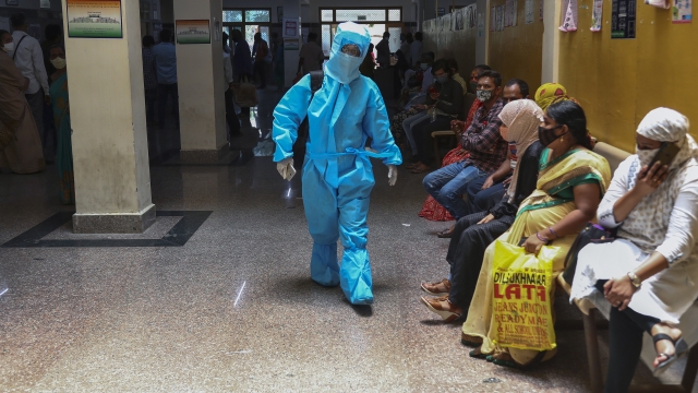 An Indian woman in personal protective suit walks towards a COVID-19 ward