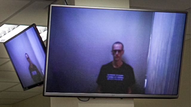 Russian opposition leader Alexei Navalny appears on TV screens via a video link from prison during a hearing in Moscow