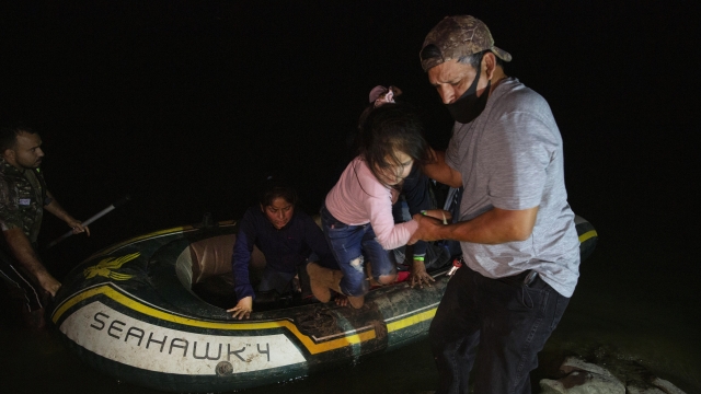 A little girl is helped off an inflatable raft by a church volunteer after being smuggled across the Rio Grande river.