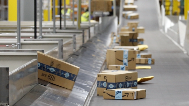 Amazon packages move along a conveyor at an Amazon warehouse facility in Goodyear, Ariz.