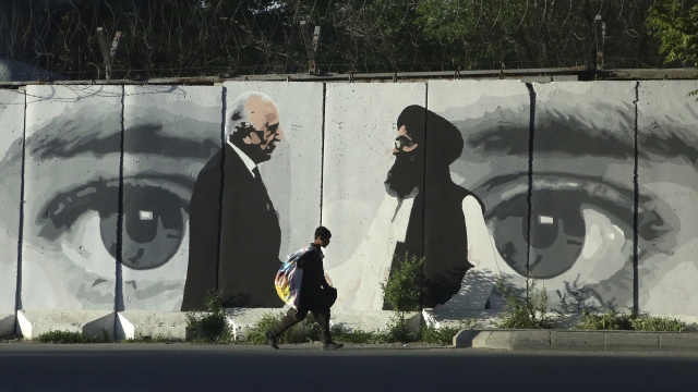 Graffiti depicts Washington's peace envoy Zalmay Khalilzad, left, and Mullah Abdul Ghani Baradar, the leader of the Taliban d