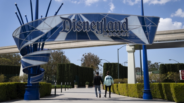 Two visitors enter Disneyland Resort in Anaheim, Calif.