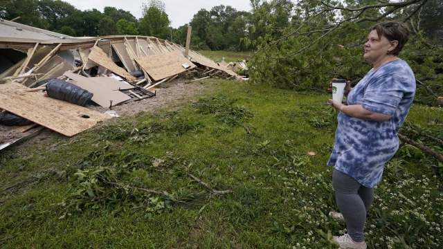Vickie Savell looks at the remains of her new mobile home early Monday
