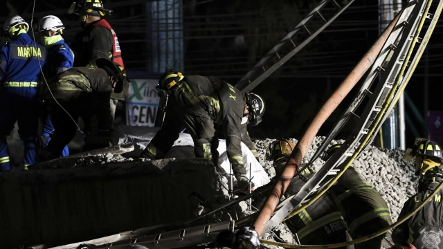 Rescue personnel retrieve bodies from the scene of an accident where subway cars fell  in southern Mexico City.