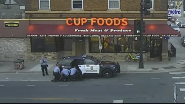 Surveillance video of Minneapolis police officers attempting to take George Floyd into custody.