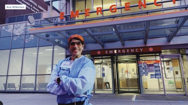 Nurse stands in front of an emergency room