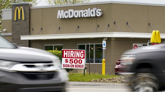 A hiring sign offers a $500 bonus outside a McDonalds restaurant.
