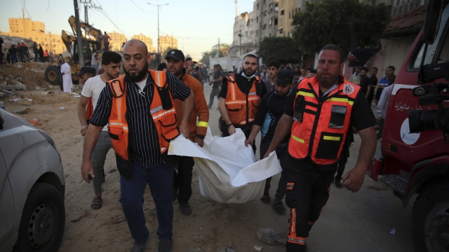 Palestinians carry the body of a child found in the rubble of a house in the Gaza Strip