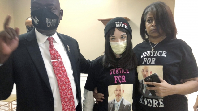 Attorney Benjamin Crump with the daughter and sister of Andre Hill.