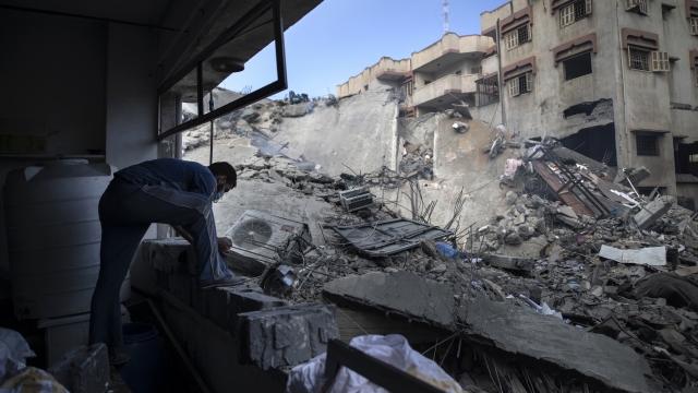 A Palestinian man inspects the damage of a six-story building which was destroyed by an early morning Israeli airstrike.