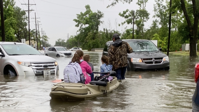 Parents use boats to pick up students from schools after nearly a foot of rain fell in Lake Charles, La.