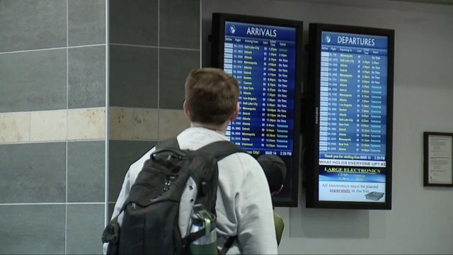 Man looks at arrivals board.