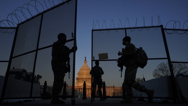 Members of the National Guard open a gate in the razor wire topped perimeter fence around the Capitol in Washington.