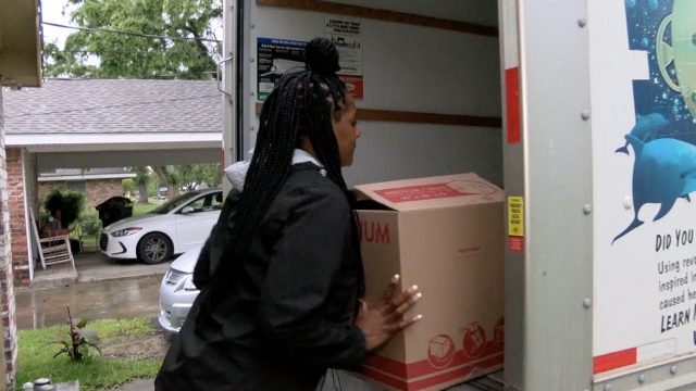 Woman loads a moving truck.