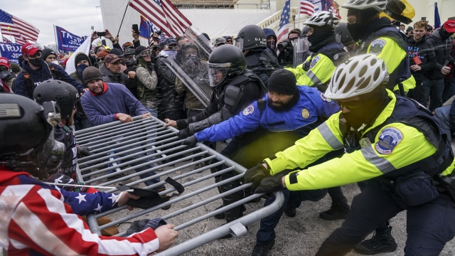 Supporters of then-President Donald Trump try to break through a police barrier, at the Capitol in Washington.