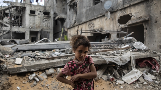Palestinian Rahaf Nuseir, 10, looks on as she stands in front of her family's destroyed homes.