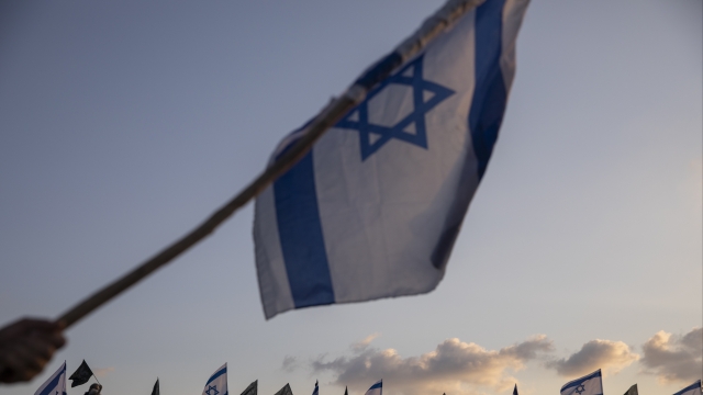 A person waves an Israeli flag.