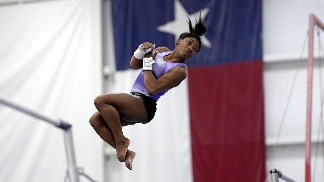 Reigning Olympic champion gymnast Simone Biles practices her routine on the uneven bars during a training session