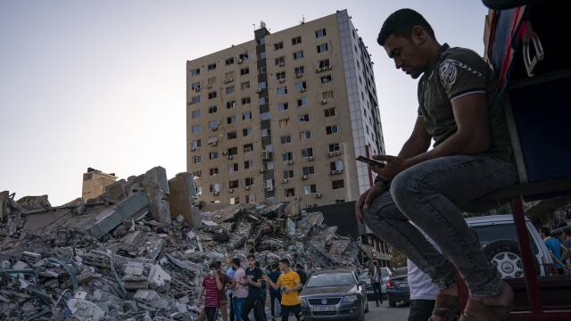 People gather to view the rubble of the al-Jalaa building following a cease-fire between Gaza's Hamas rulers and Israel.